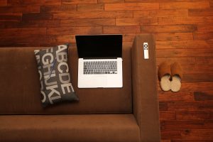 laptop computer on sofa, with slippers on floor