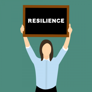 person hold small board with word "resilience" written on it