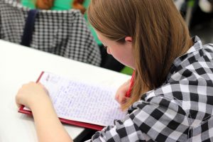 student writing in a notebook